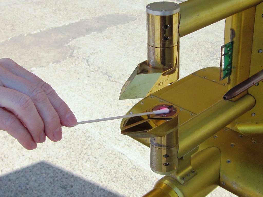 Before a BBOP flight, a scientist cleans a probe mounted on a pylon of ARM’s G-1 research aircraft.