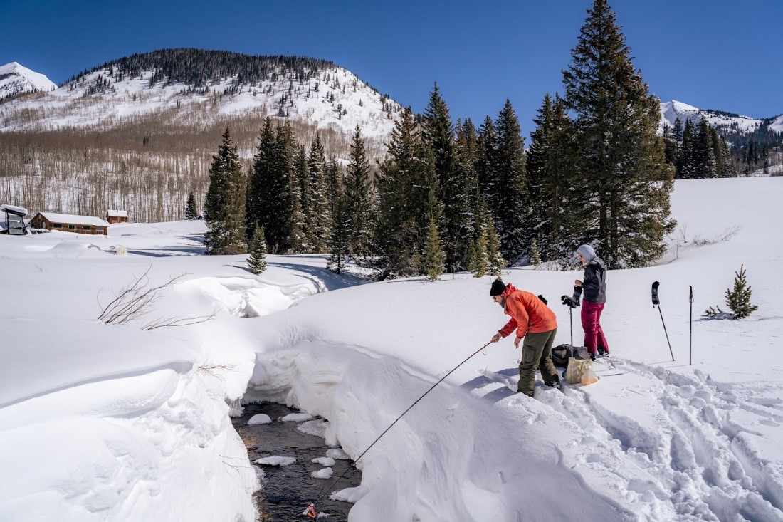 Alexander Newman (left) of the Rocky Mountain Biological Laboratory inserts a probe into a stream in the SAIL study area. Next to him is Marianne Cowherd, a PhD candidate from the University of California, Berkeley. Photo is by Jeremy Snyder, Lawrence Berkeley National Laboratory.