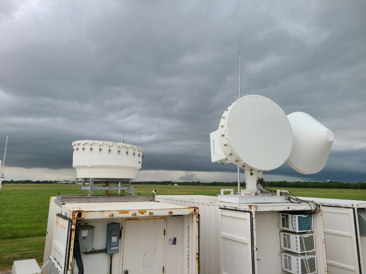 On April 25, 2022, afternoon convection looms on the horizon behind ARM radars collecting data in La Porte, Texas, during the TRacking Aerosol Convection interactions ExpeRiment (TRACER). Photo is by Mark Spychala, Hamelmann Communications.