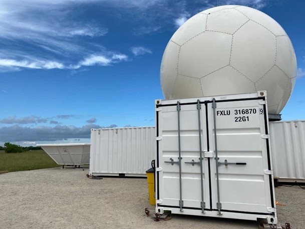 In the foreground at ARM’s TRACER instrument site in Pearland, Texas, is a C-Band Scanning ARM Precipitation Radar, which tracks storm cells. To the left, in the back, is a radar wind profiler. Photo is by Jillian Sandoval, Los Alamos National Laboratory.